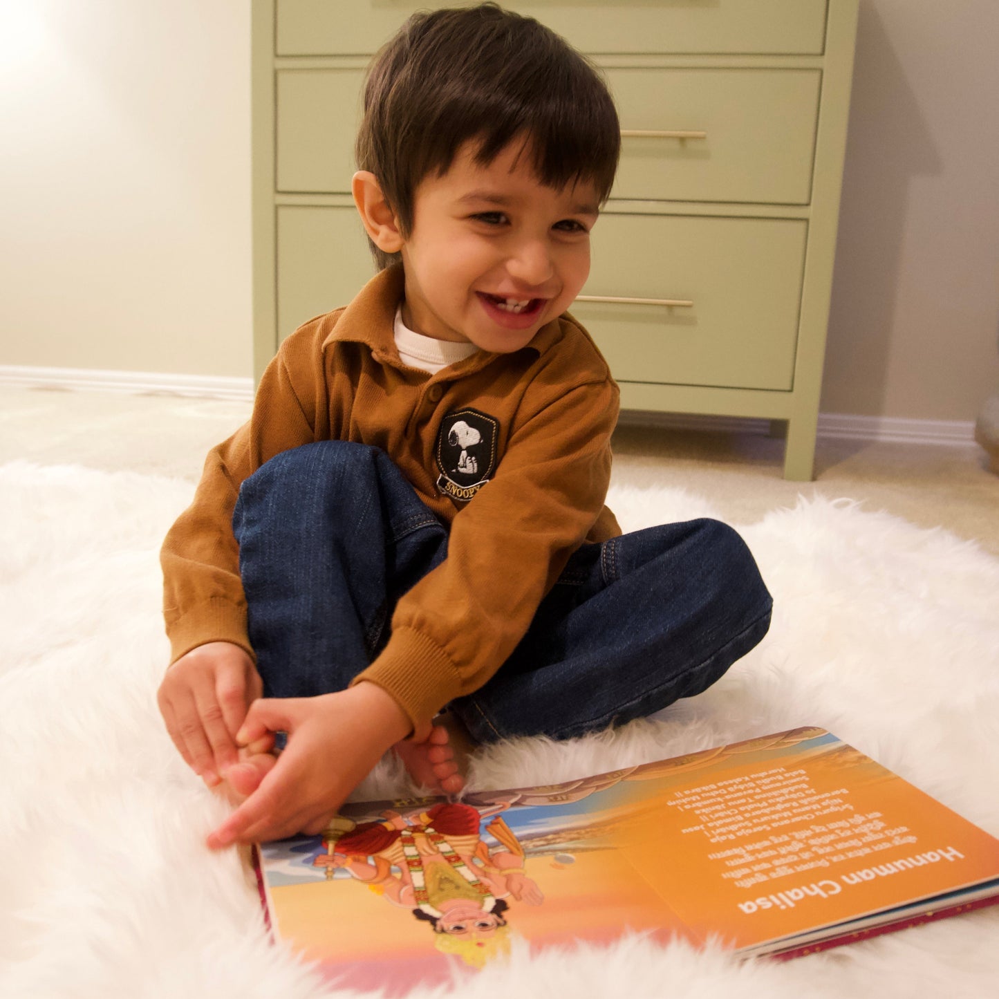 A child interacting with the Hanuman Chalisa mantra in the Shlokas For Babies book
